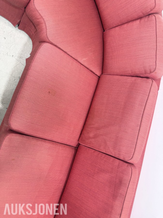 Stor rød hjørnesofa med rundt salongbord