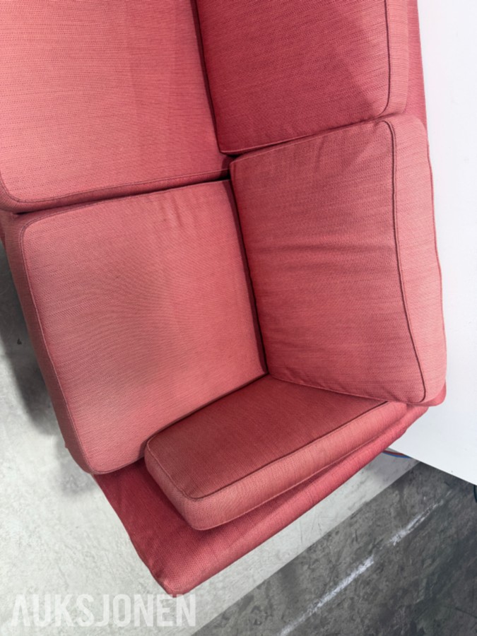 Stor rød hjørnesofa med rundt salongbord
