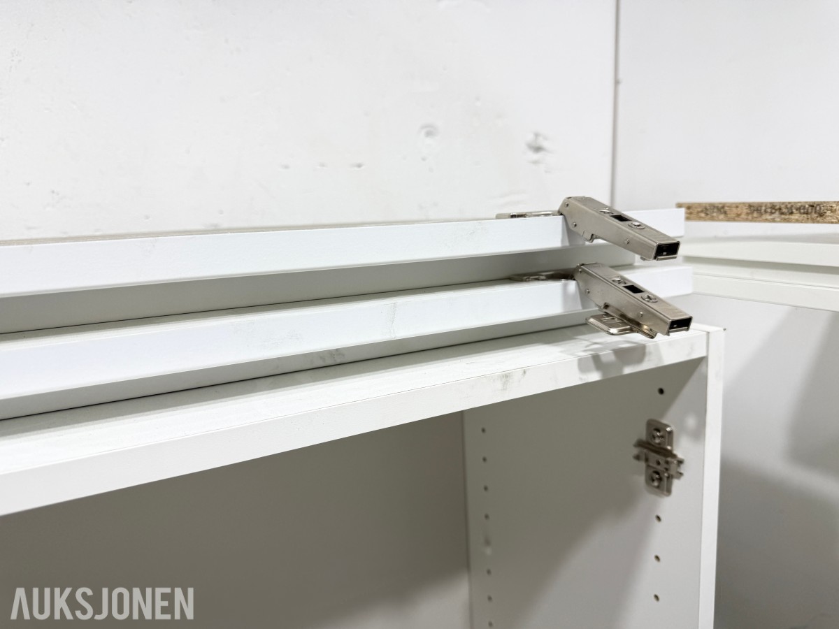 Hvite skapmoduler med dører og hyller